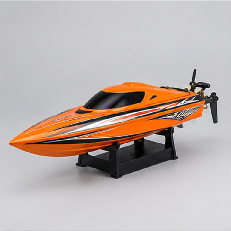 Orange remote control speed boat with display stand on a neutral studio background